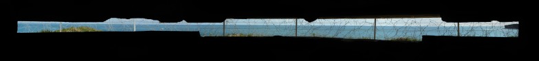 A view from inside of the German bunker looking out over barbed wire to the sea.
